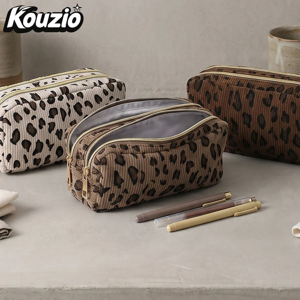 A brown leopard print double zipper pencil case resting on a light surface.