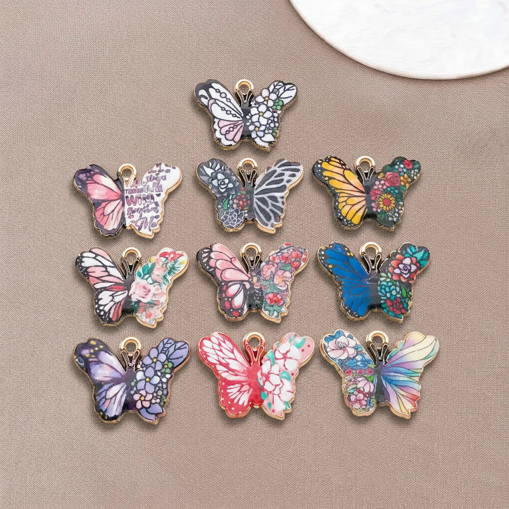 A set of colorful butterfly enamel charms featuring various floral and patterned designs.