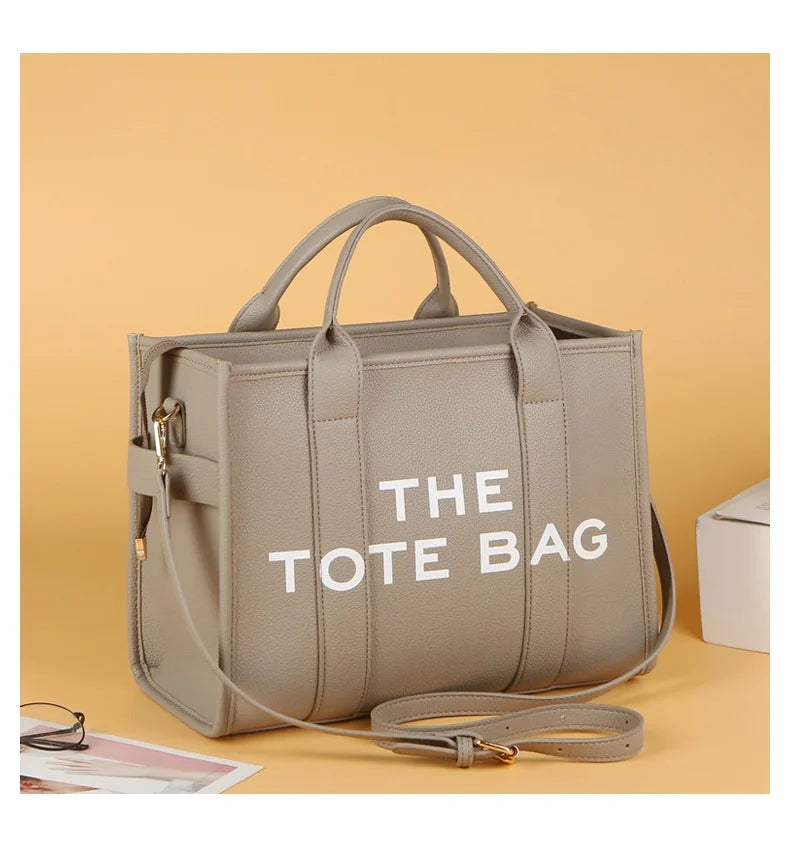 Sac cabas luxe en PU beige avec sangles en cuir, présenté sur un fond brun clair.