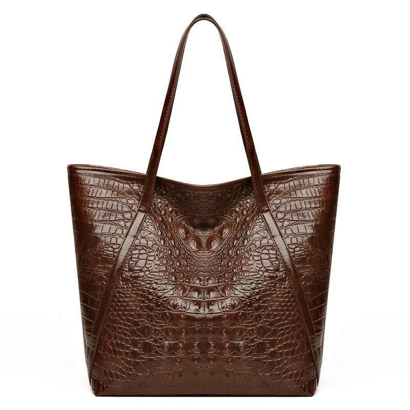 A brown crocodile print tote bag with a leather strap shown from the front.