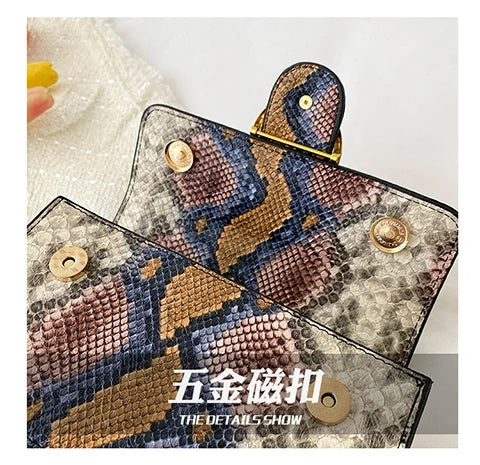 A close-up of an elegant retro crossbody bag featuring a brown and blue snakeskin pattern on a light background.
