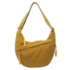 A mustard yellow canvas crossbody bag with tan leather straps.
