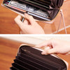 A close-up of a black PU leather zipper clutch wallet being held by a hand.