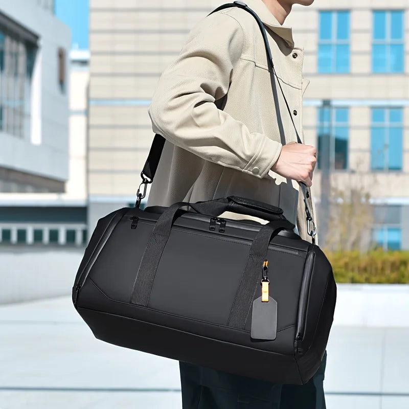 Une personne porte un grand sac de voyage noir à l'épaule en extérieur.