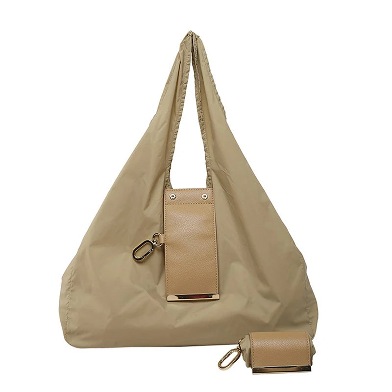 A beige cloth storage pouch with a leather strap and attached keychain bag.