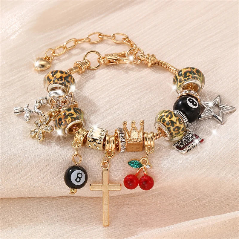 A gold and leopard print beaded bracelet featuring crosses, stars, and black beads.