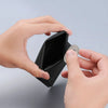 A hand is opening a black magnetic foldable ID card holder to reveal a coin inside.