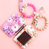 A pink silicone bead and PU leather key chain wallet with floral patterns and a beaded bracelet.