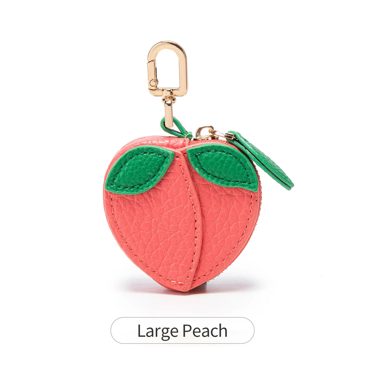 A large peach shaped coin purse keychain in coral pink with green leaves and a gold-colored hook.