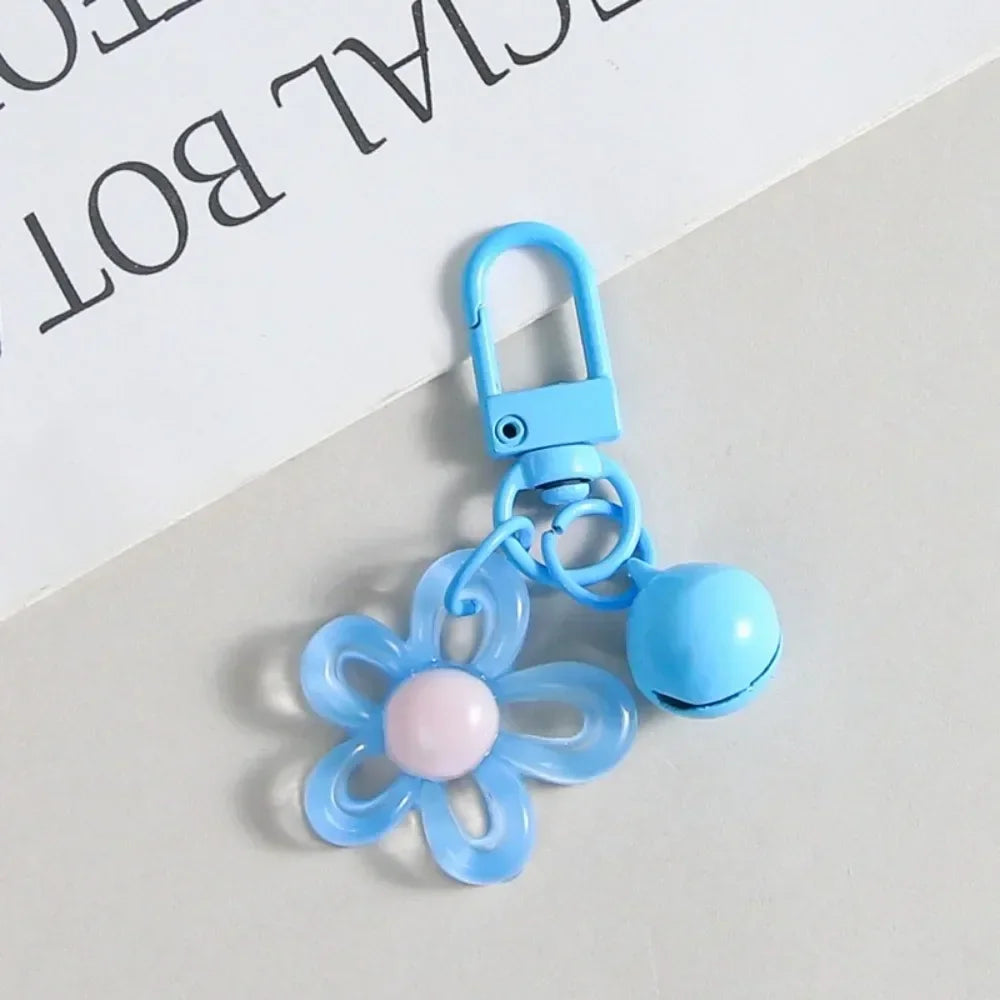 A light blue resin flower keychain with a silver clasp and a round blue bead.