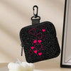A black leopard print coin purse and multi-use earphone case with pink hearts
