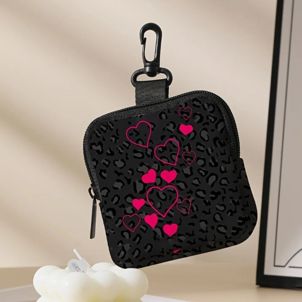 A black leopard print coin purse and multi-use earphone case with pink hearts