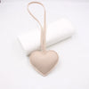 A light beige PU leather heart-shaped keychain with a thin loop attached.