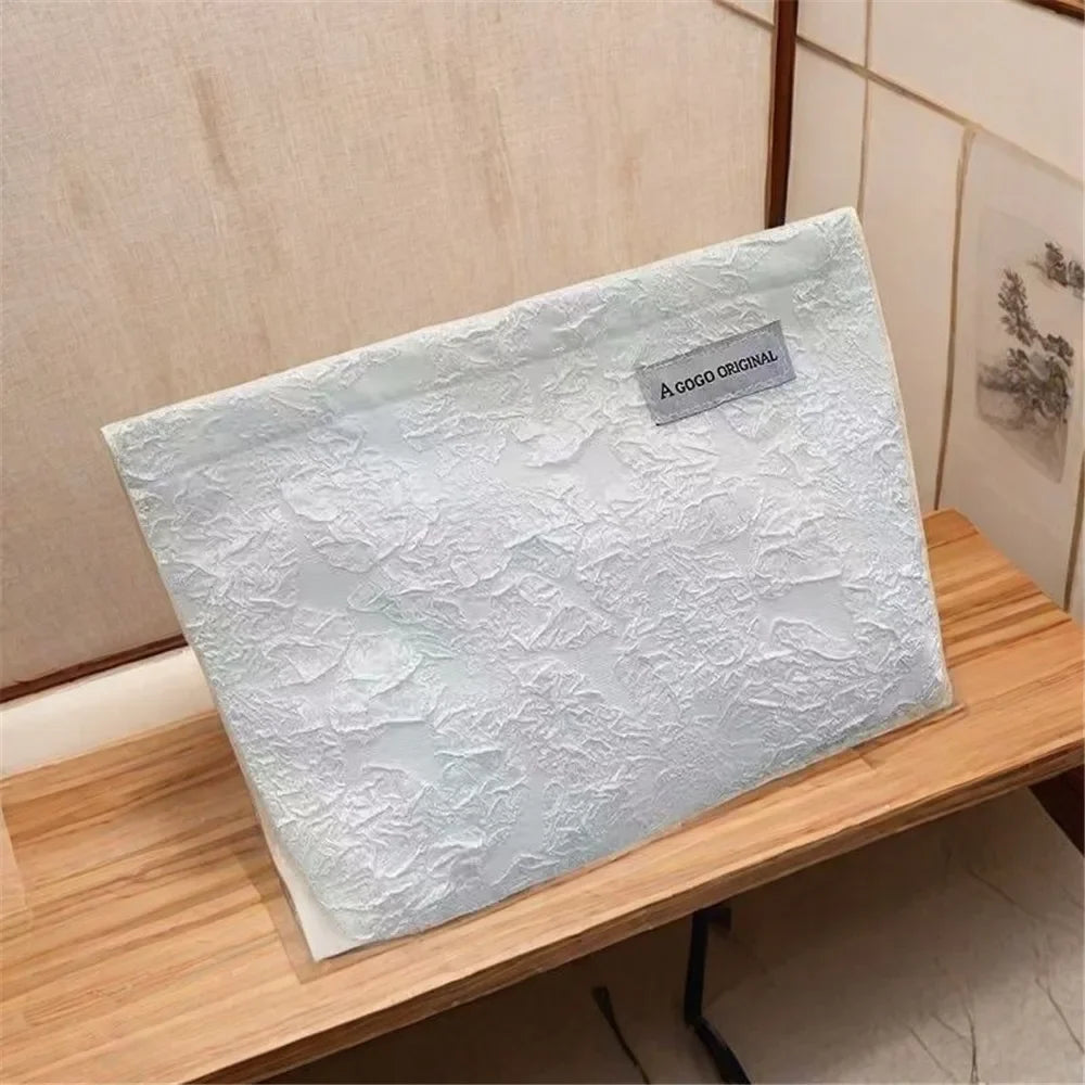 Bolsa de almacenamiento con cremallera de lona blanca para electrónica, exhibida en una estantería de madera.