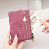 Una mano sostiene una cartera de cuero PU plegable retro mauve con herrajes dorados contra un fondo claro.