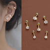 A set of gold-toned stainless steel stud earrings featuring various diamond and clear stones.