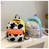 A women's cow print fashion backpack in white and black with orange accents, sitting on a white surface.