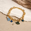 A gold chain bracelet featuring ocean pearl, blue, and gold accents with a starfish charm.