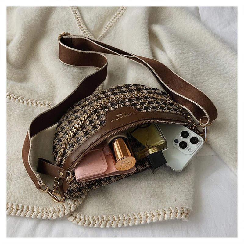 A brown and black leopard print crossbody shoulder bag with a tan strap resting on a cream-colored towel.