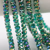 Green and blue faceted crystal glass beads in a wheel shape strung on a string