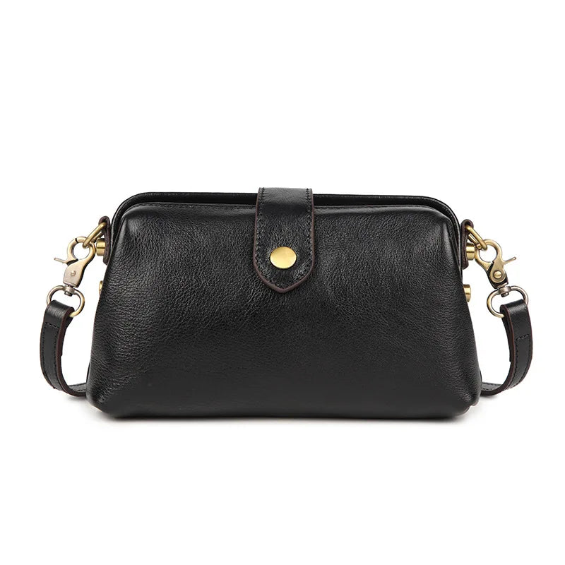 A black genuine leather crossbody bag with a flap and gold-toned hardware.