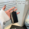 A hand holds a black and silver cloth storage pouch keychain accessory bag.