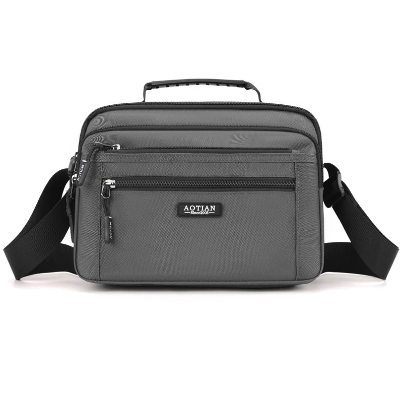 A gray compact waterproof crossbody messenger bag with black strap and zipper.