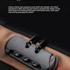 A close-up of a black anti-theft lock mechanism with three slots and a push button, shown on a brown fabric.