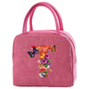 A pink insulated canvas lunch bag featuring a floral butterfly design.