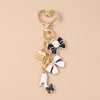 Gold enamel heart keychain with a bow and a white shoe charm