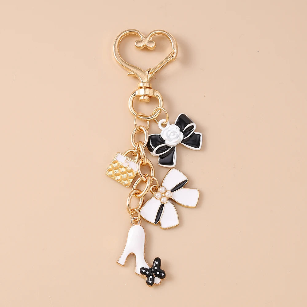 Gold enamel heart keychain with a bow and a white shoe charm