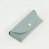 A light blue PU leather hard shell sunglasses case lying on a white surface.