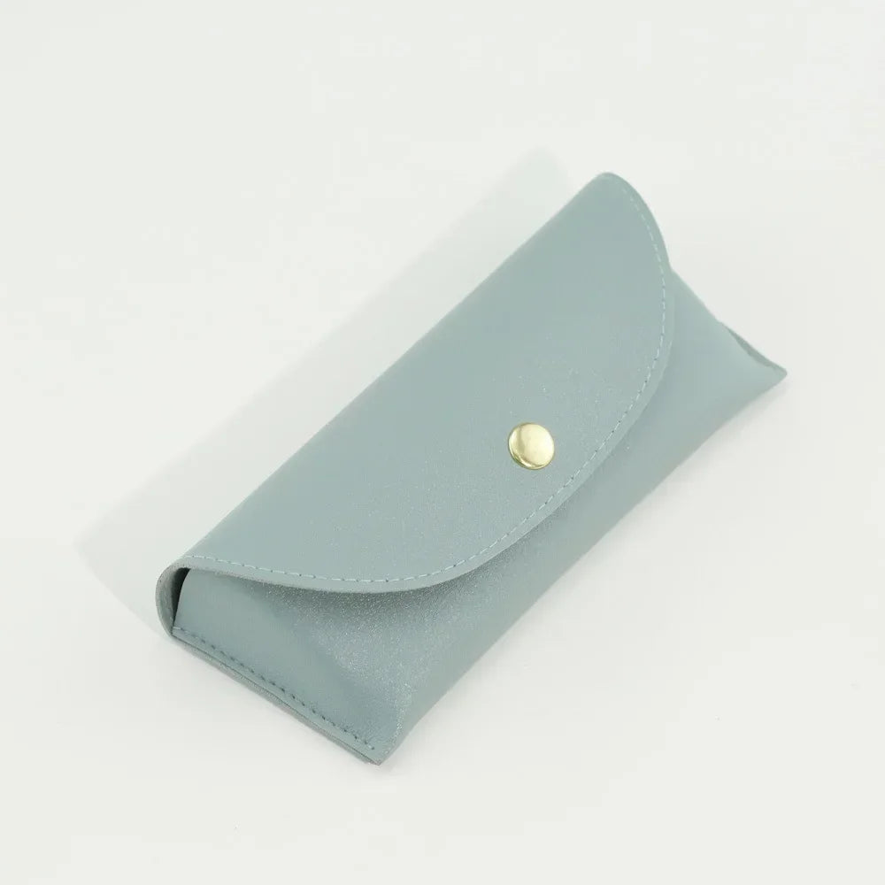 A light blue PU leather hard shell sunglasses case lying on a white surface.