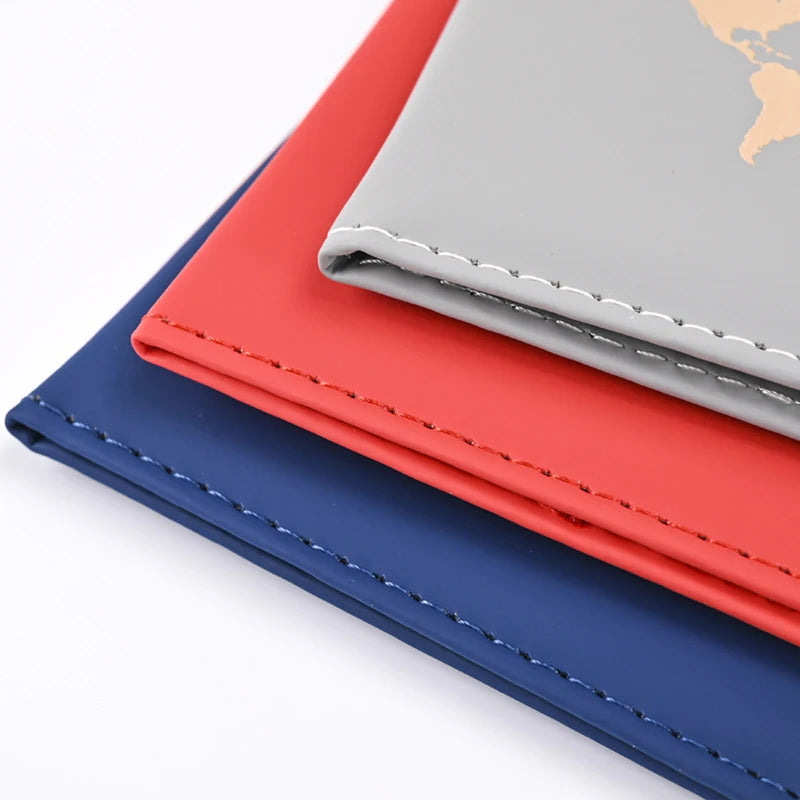 Three elegant PU leather passport holder wallets in blue, red, and gray stacked diagonally.