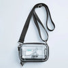 A clear plastic cosmetic bag with a black strap is shown against a white background.