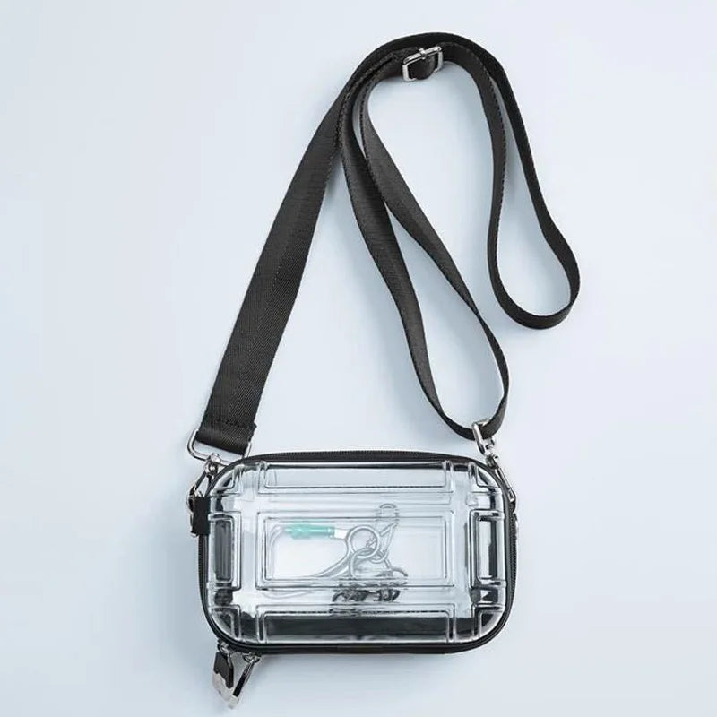 A clear plastic cosmetic bag with a black strap is shown against a white background.