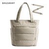 Sac fourre-tout rembourré beige avec une sangle beige clair sur fond blanc.