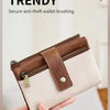 A close-up of a brown leather wallet with brass hardware and a beige lining, being held by a hand.