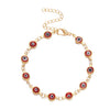 Gold charm bracelet featuring blue and red evil eye beads on an adjustable chain.