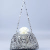 A handmade dumpling bag covered in silver and gold beads with a sheer, beaded handle.