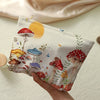 A beige makeup bag featuring a fairytale mushroom and butterfly print, held by a hand against a light background.