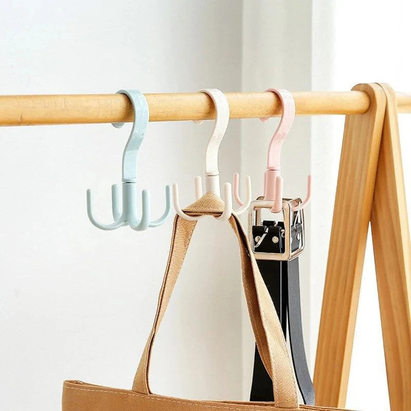 A set of four multi-functional hanging hooks in pastel colors are displayed on a wooden rack.