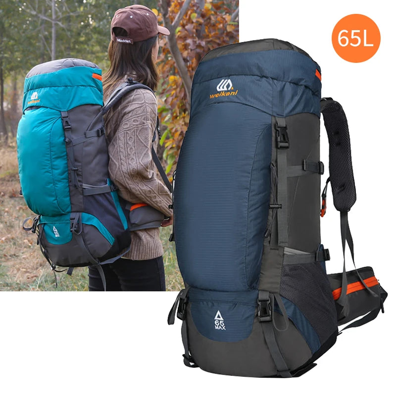 Sac à dos d'escalade imperméable bleu foncé et noir de 65L porté par une personne à l'extérieur.