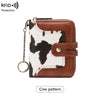 Brown leather bifold wallet with a white cow pattern insert and a silver chain.