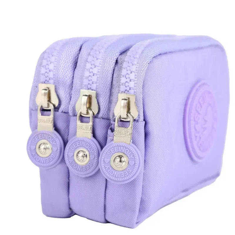 A purple compact three-layer nylon zipper pouch with gold-toned hardware.
