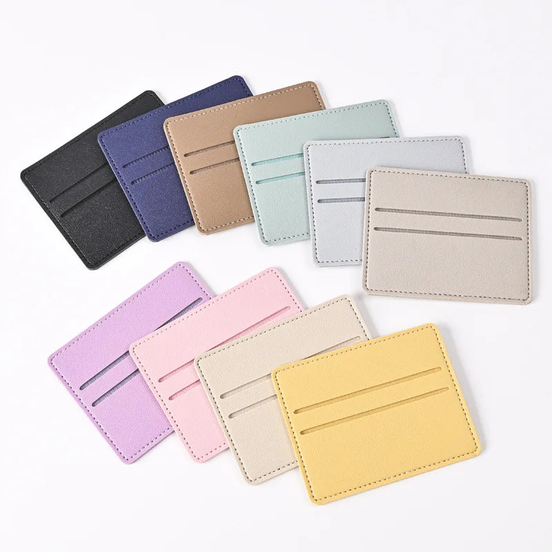 Una colección de diez porta tarjetas de cuero PU en varios colores pastel y neutros, dispuestos en diagonal.