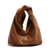 A brown leather minimalist crossbody tote bag folded and displayed against a white background.