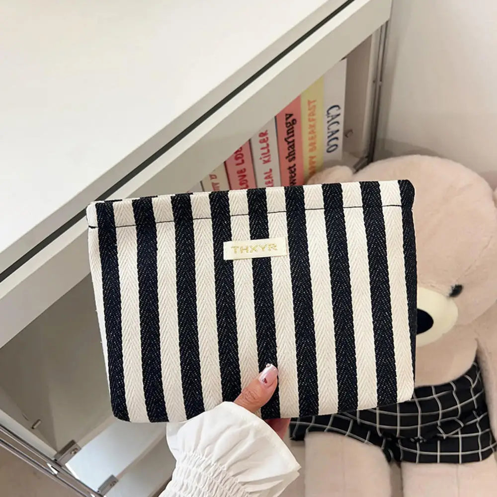 Pochette en crochet rayée tissée noir et blanc, affichée dans une armoire blanche.