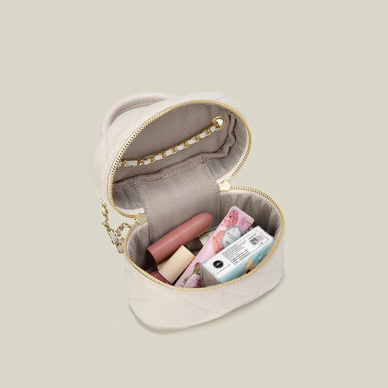 Petit sac bandoulière matelassé beige clair avec une chaîne dorée, ouvert pour montrer son intérieur et son espace de rangeme