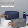 A dark blue and gray portable storage bag for toiletries is displayed on a white surface.